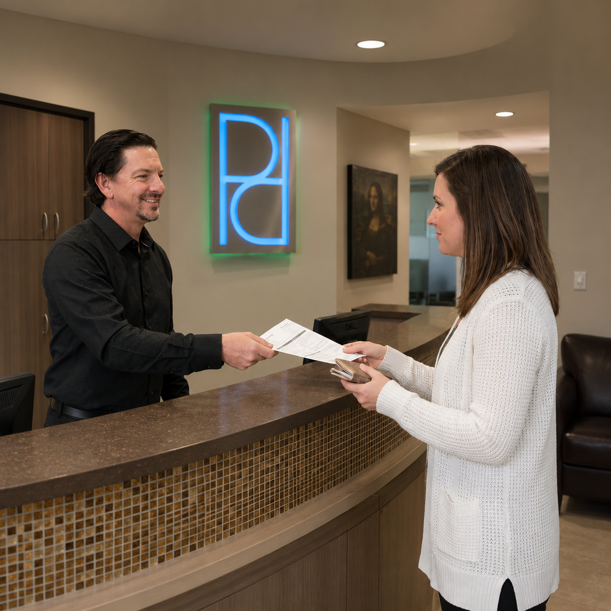 A dentist gives paperwork to a patient at the Parkway Dental reception desk in Albuquerque during a check-in.