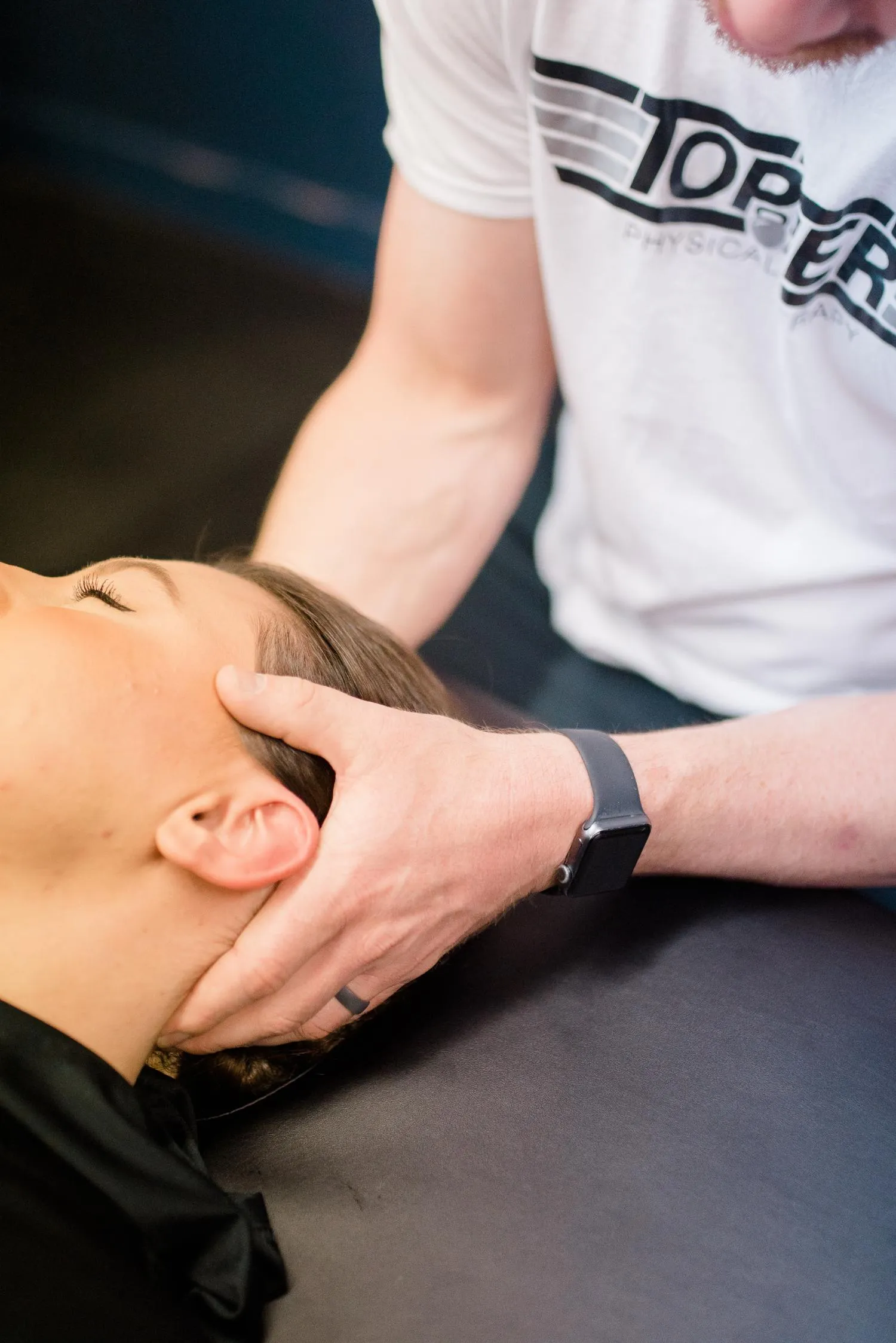 Physical therapist performing manual therapy on a client's neck at Top Tier Physical Therapy in Middletown, DE.