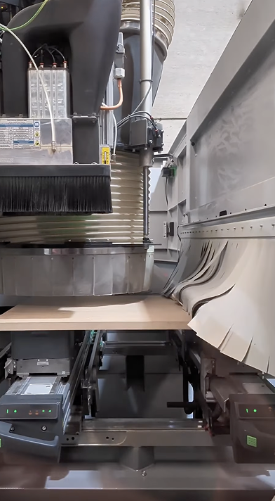 Máquina industrial procesando una pieza de madera clara horizontalmente.