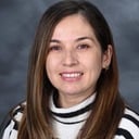 Patty Salazar smiling in a striped turtleneck sweater