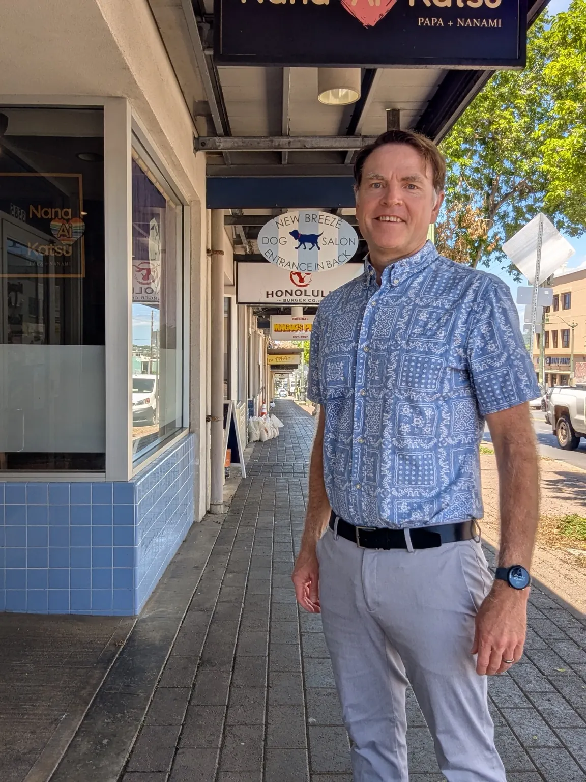man-smiling-outside-honolulu-shopfront