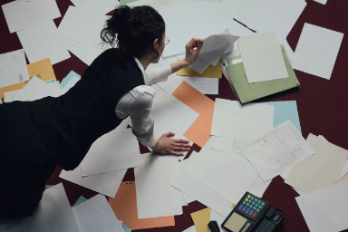 Woman looking over strategy documentation laid out on floor