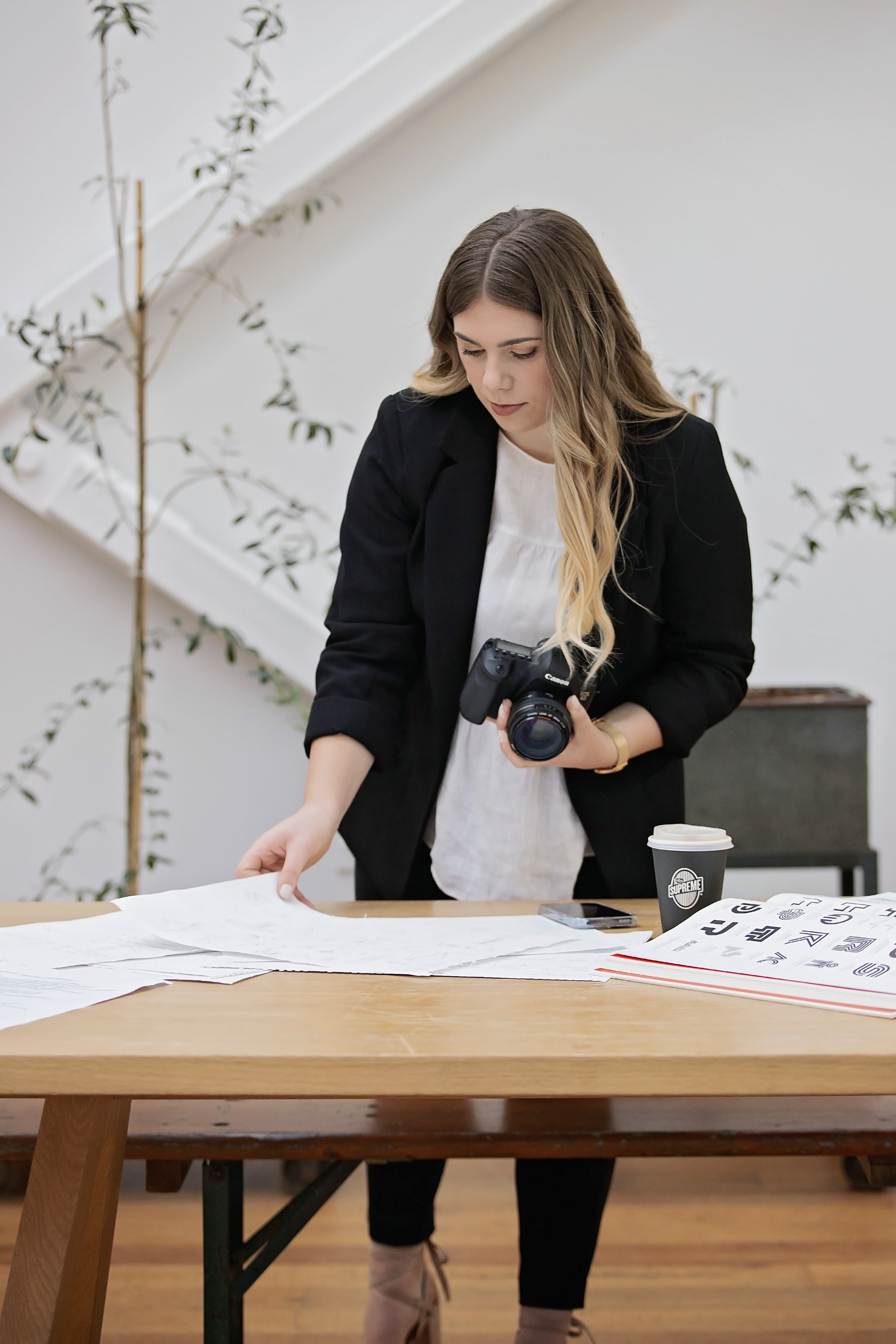 Islay Wharton looking at photoshoot shot list, on set, while holding a camera
