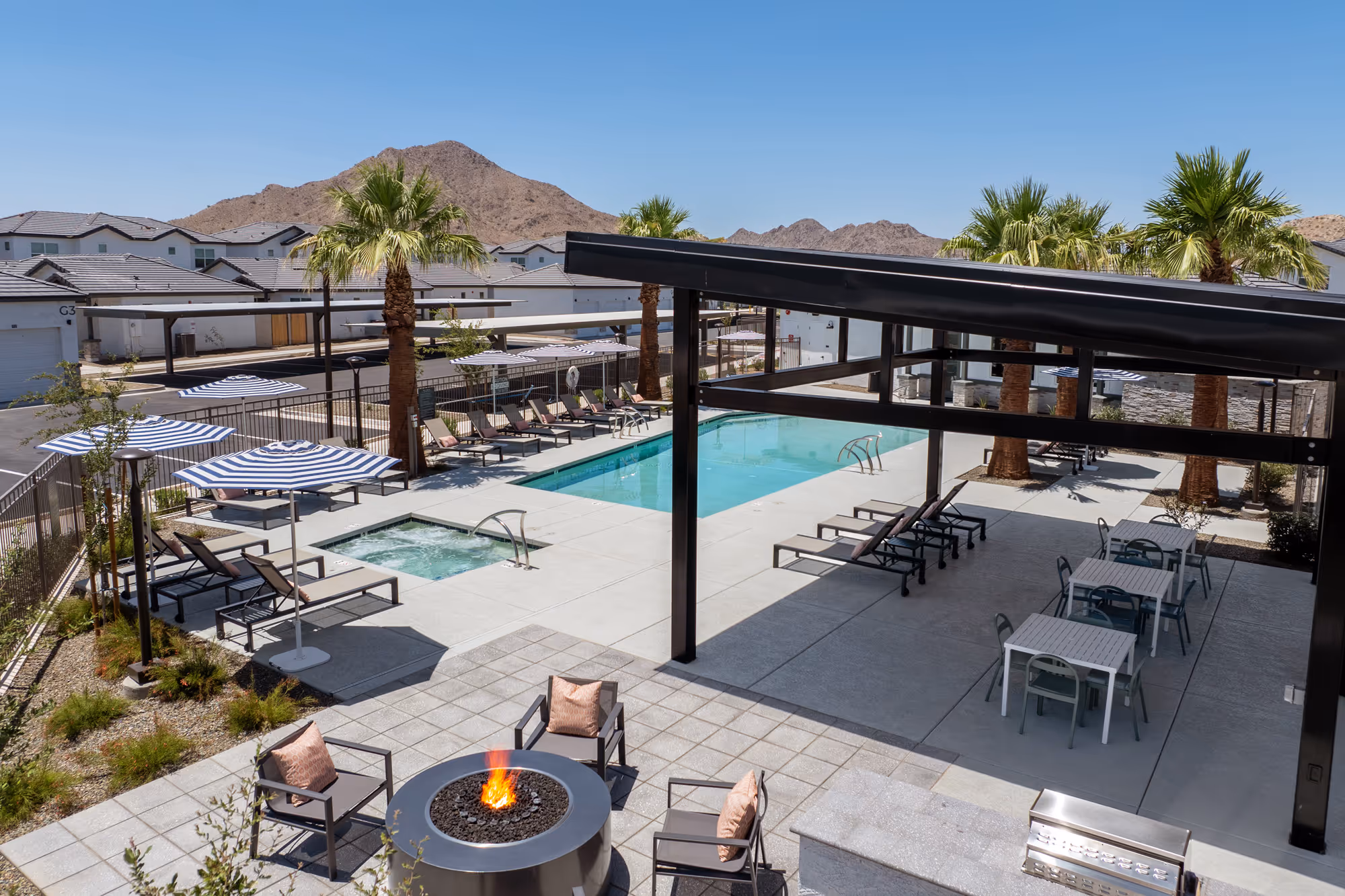 Pool with cabana and lounge chairs and tables