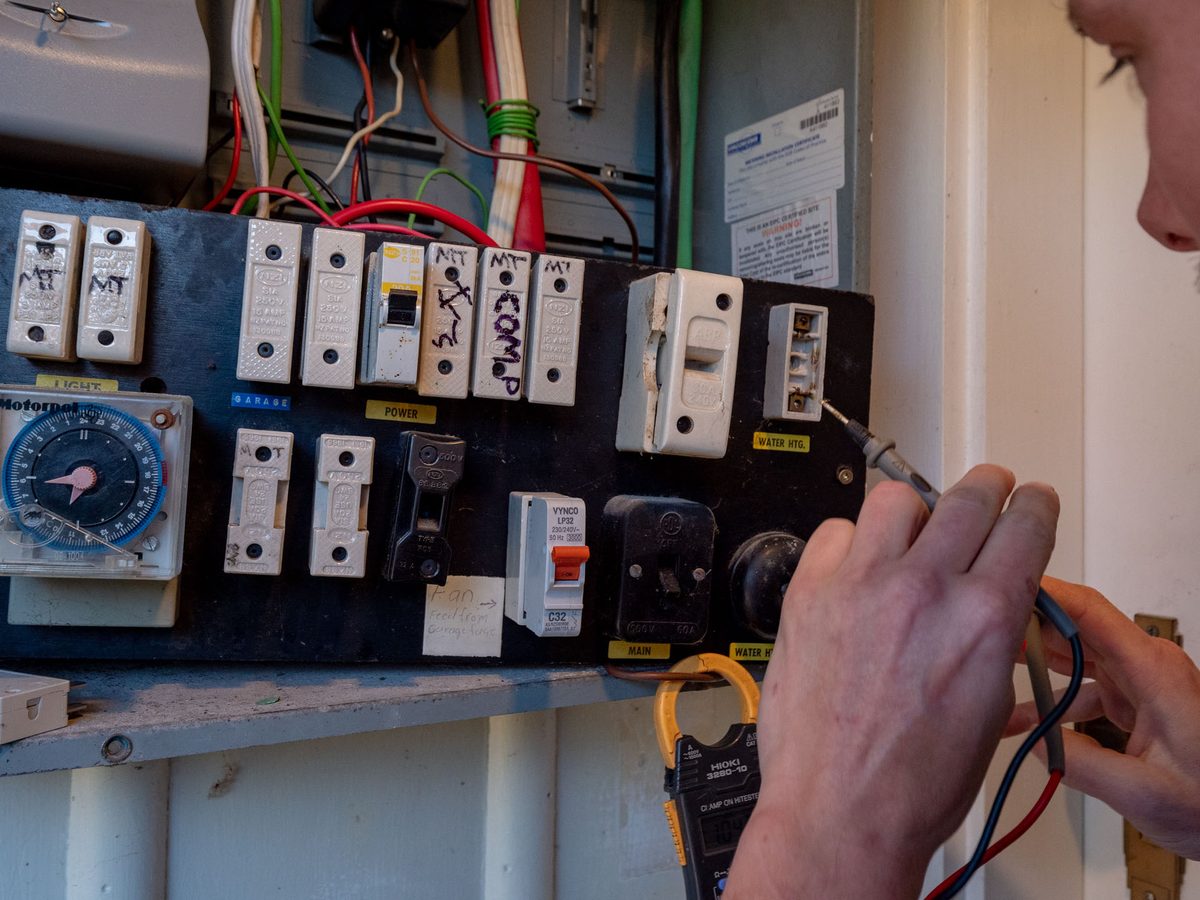 Testing an older switchboard full of circuit breakers during an eCertify inspection