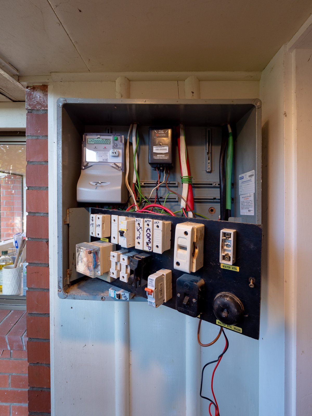 A meter box set into the brick wall of an Auckland home