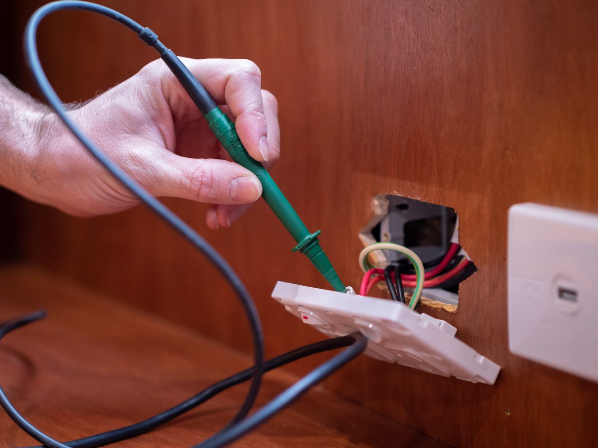 Testing a power socket inside a home during an eCertify pre-sale inspection