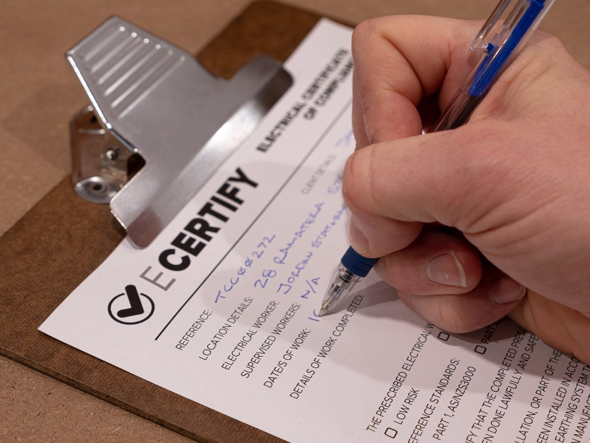 An eCertify inspector filling in an electrical certificate by hand
