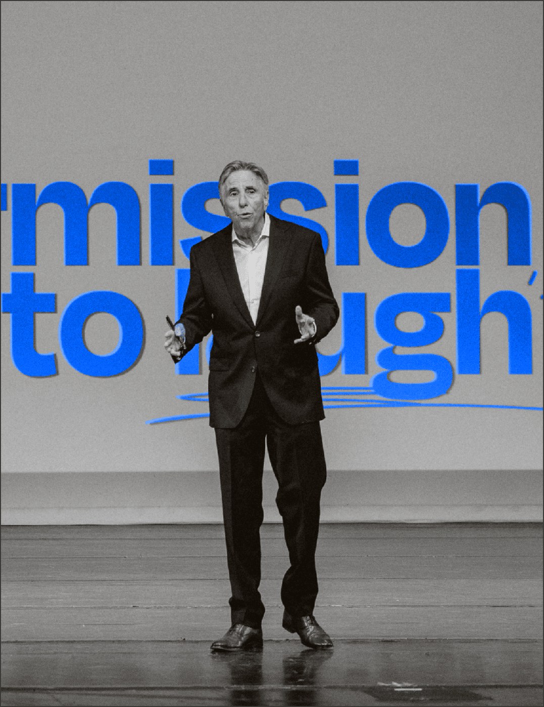 Bernie Smilovitz on stage delivering his Permission to Laugh keynote in black and white