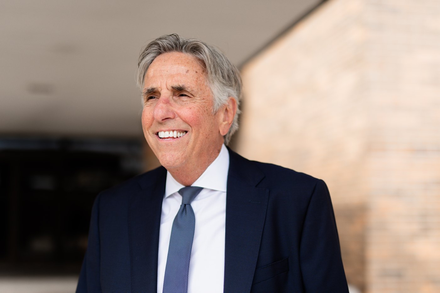 Bernie Smilovitz smiling in a close-up headshot in a navy suit outdoors
