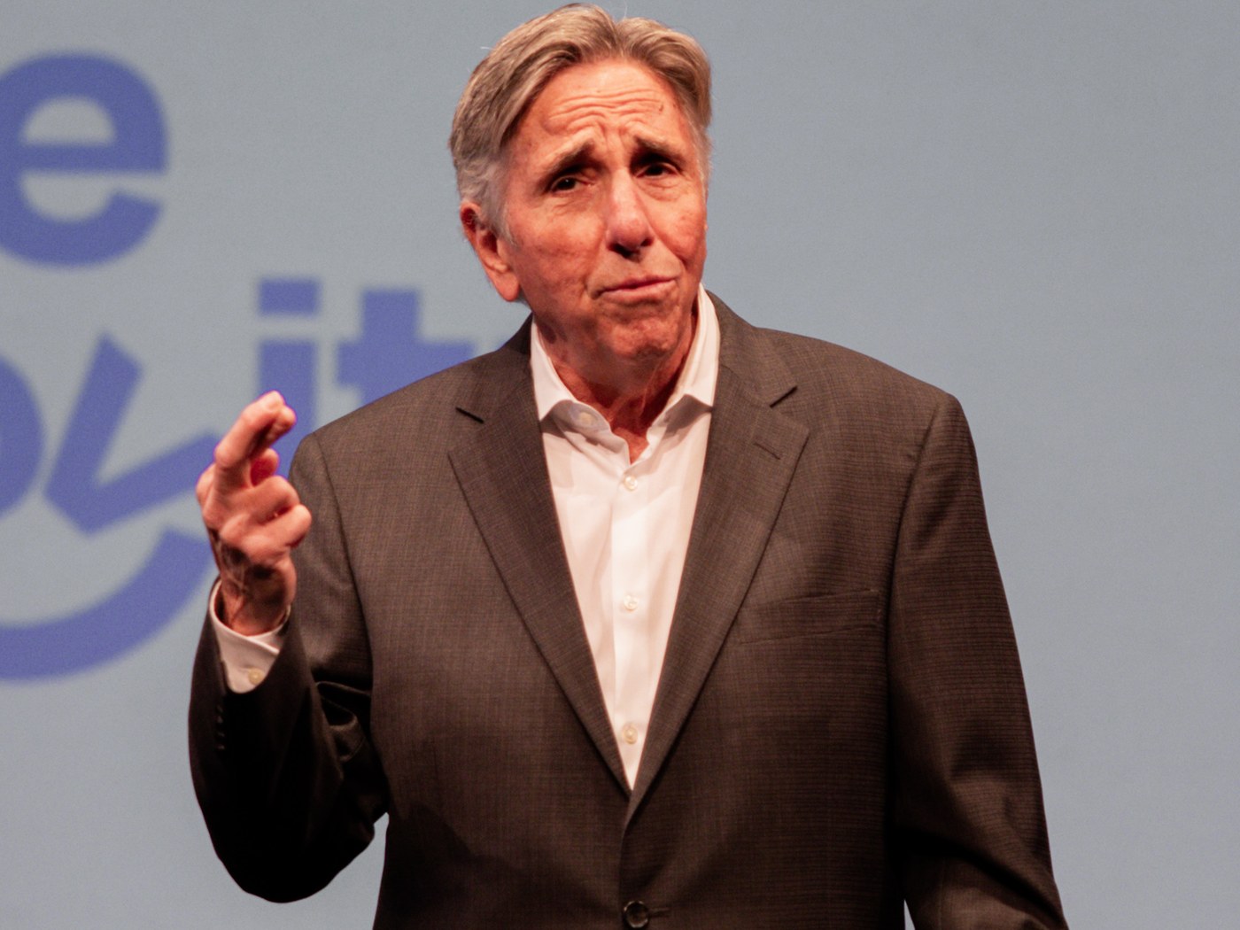 Bernie Smilovitz pointing with an animated expression while speaking on stage