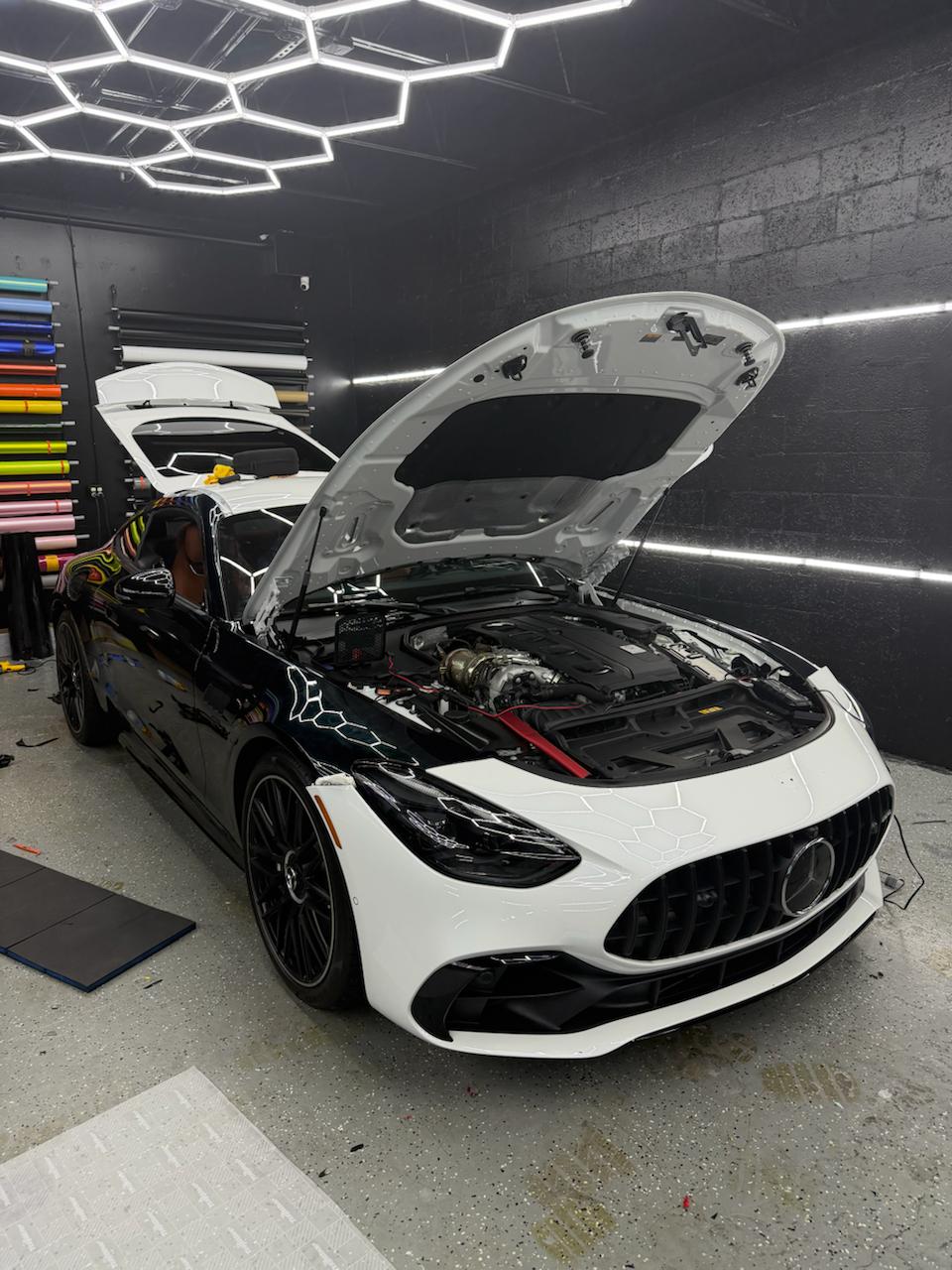 Two-tone Mercedes-AMG GT mid-install with hood open at Wrap Me USA Miami
