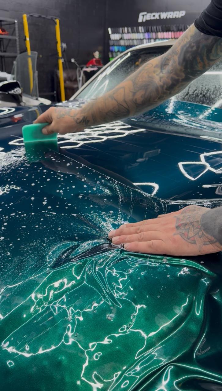 Technician squeegeeing ceramic tint film with slip solution at Wrap Me USA
