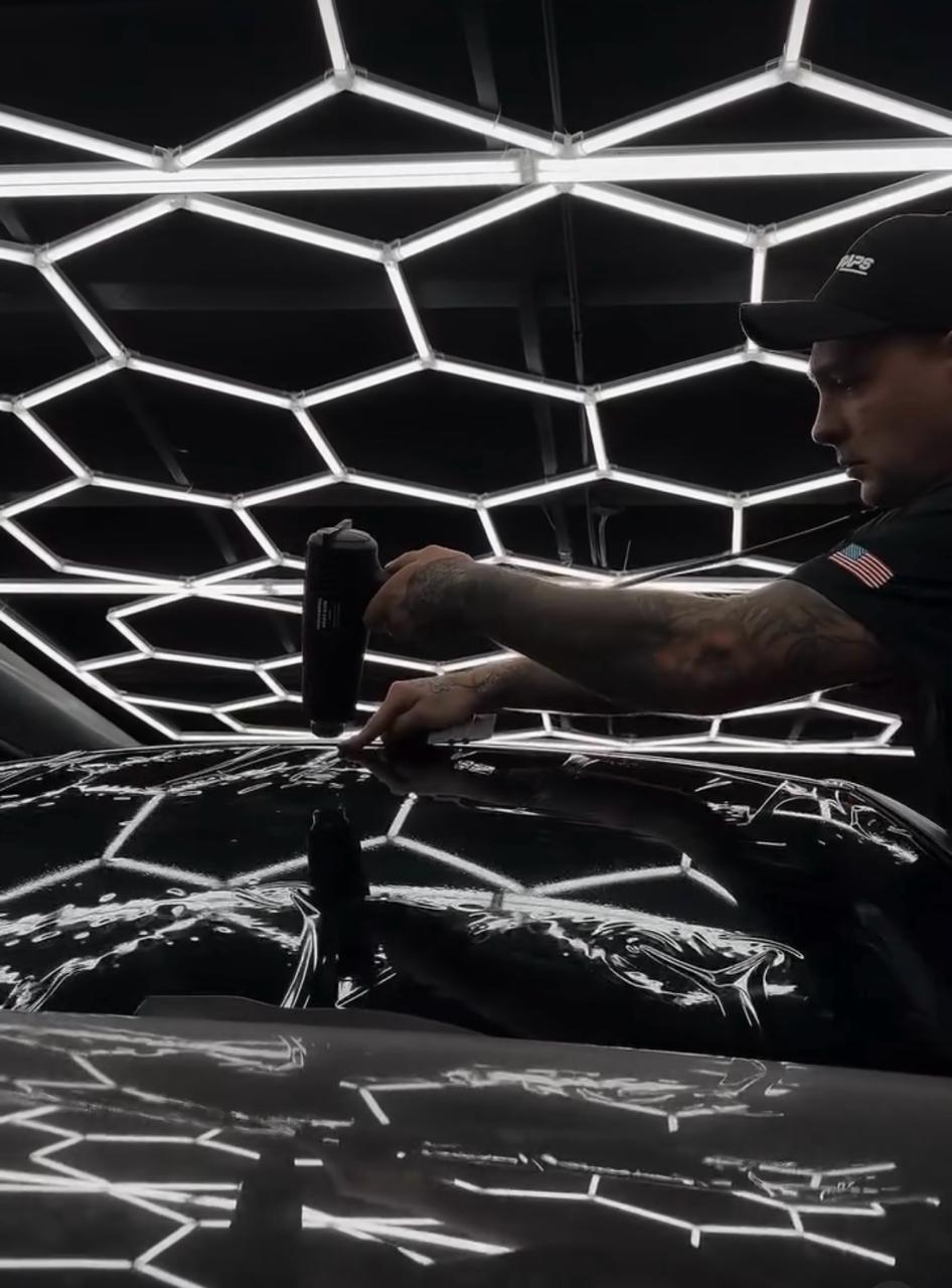 Wrap Me USA technician precision-cutting paint protection film on a black hood