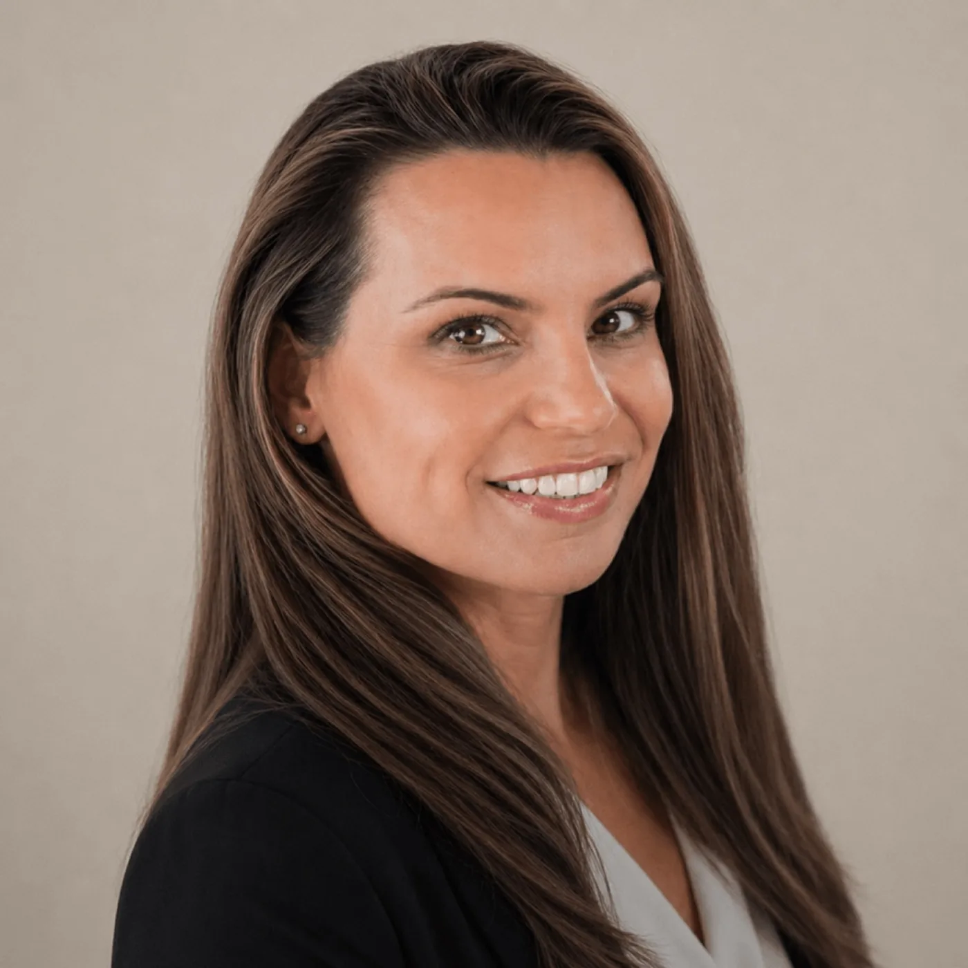 Professional headshot of Suzie Murphy, a woman with long brown hair with highlights, smiling warmly, wearing a black blazer over a light top.