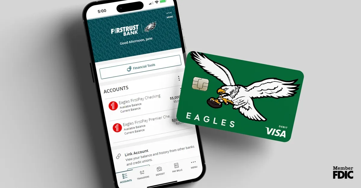 Smartphone showing FirstTrust Bank Eagles accounts next to a green Eagles Visa debit card.