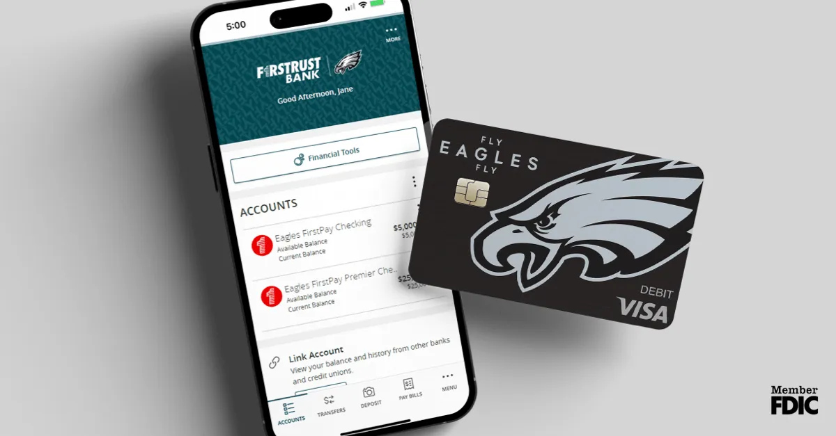 Smartphone screen showing FirstTrust Bank app with Eagles FirstPay accounts and Eagles-themed Visa debit card.