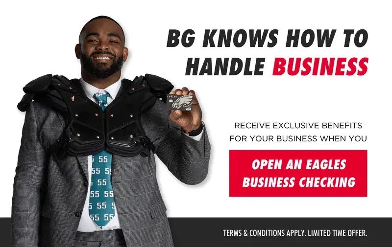 Man in suit and football shoulder pads holding Eagles business card, promoting Eagles business checking account.