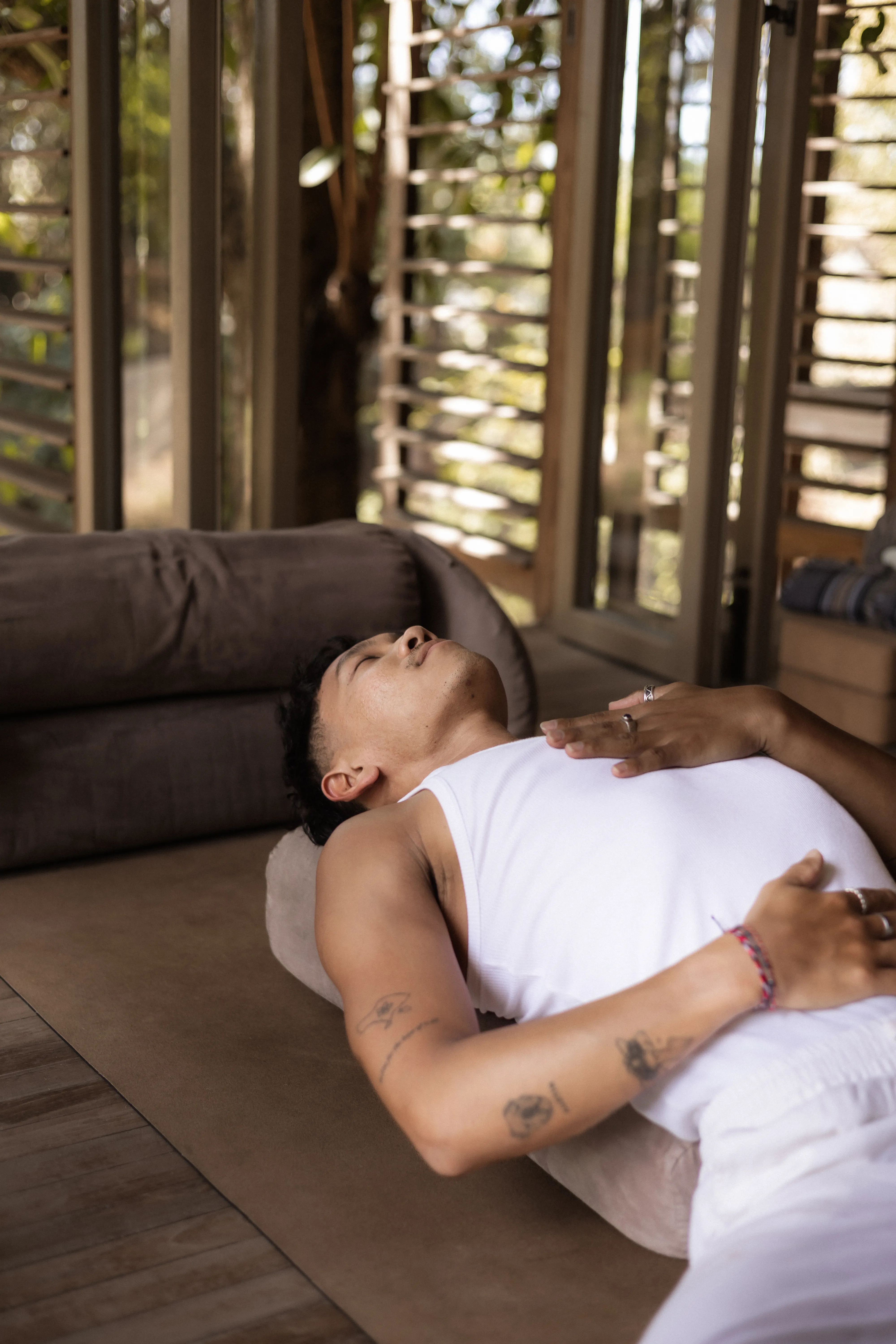A practitioner lying comfortably on a cushioned bolster during a guided meditation session at The Shaba Shala.