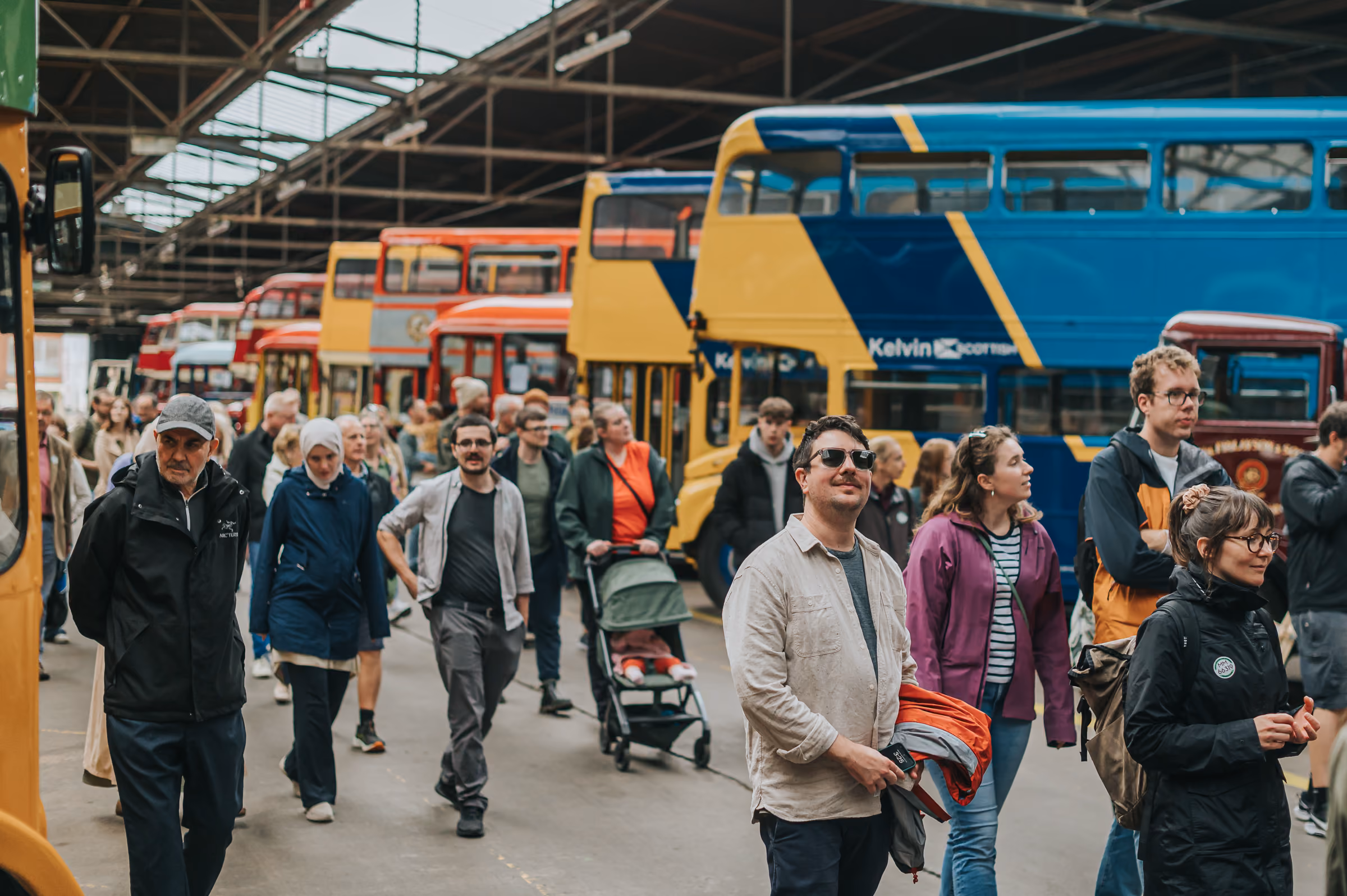 Crowd exploring historic buses during a Glasgow event