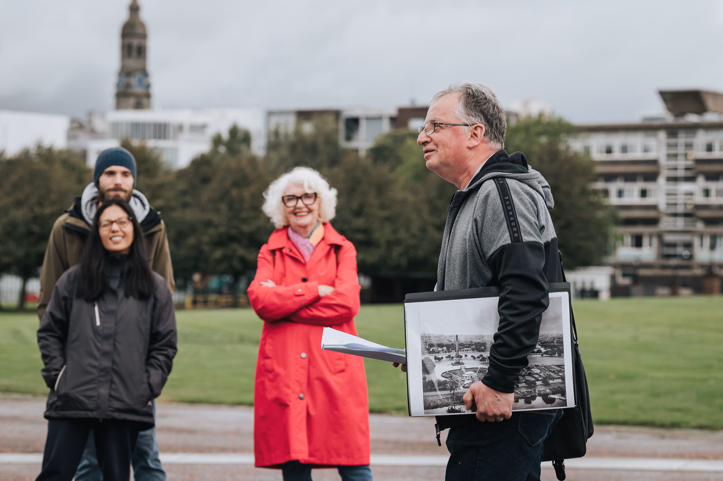 Community guide speaking to visitors in a park