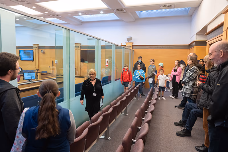 People visiting a public building during a guided tour, with a staff member explaining the facilities.