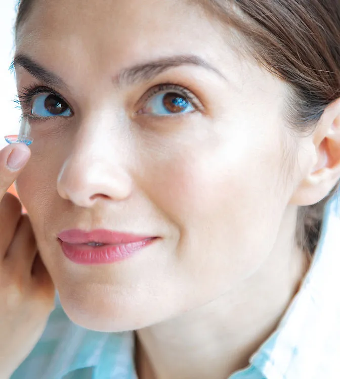 Optician fitting a patient with contact lenses
