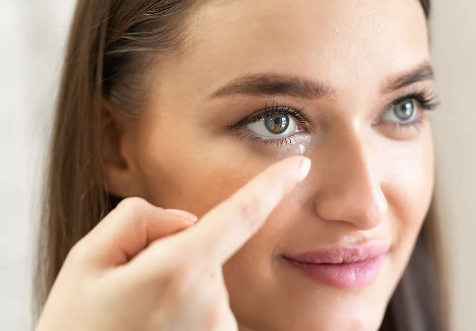 Woman applying contact lenses