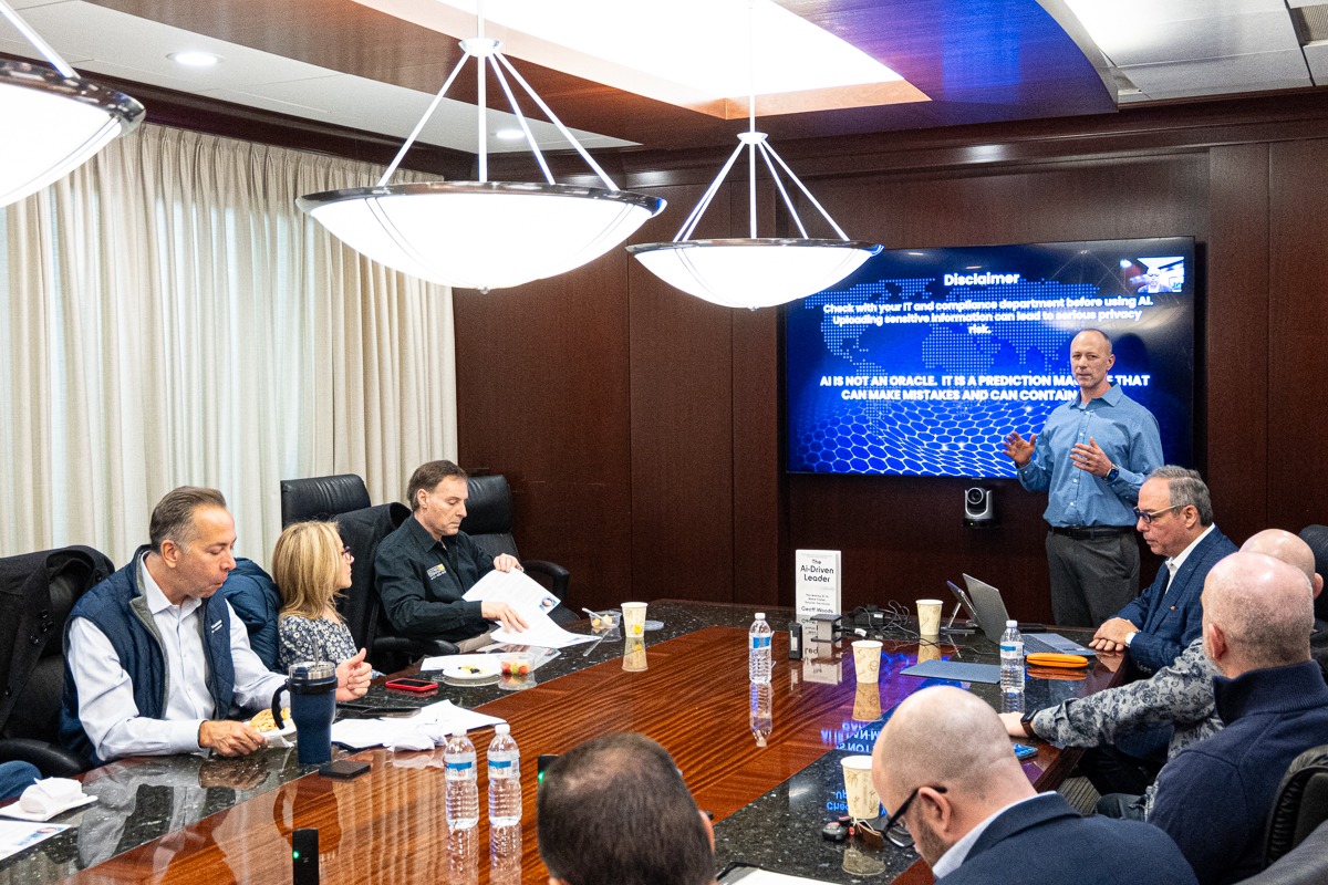 Wide boardroom view of Steven Giacoppo presenting practical AI workflow training to a Long Island Business Impact Group