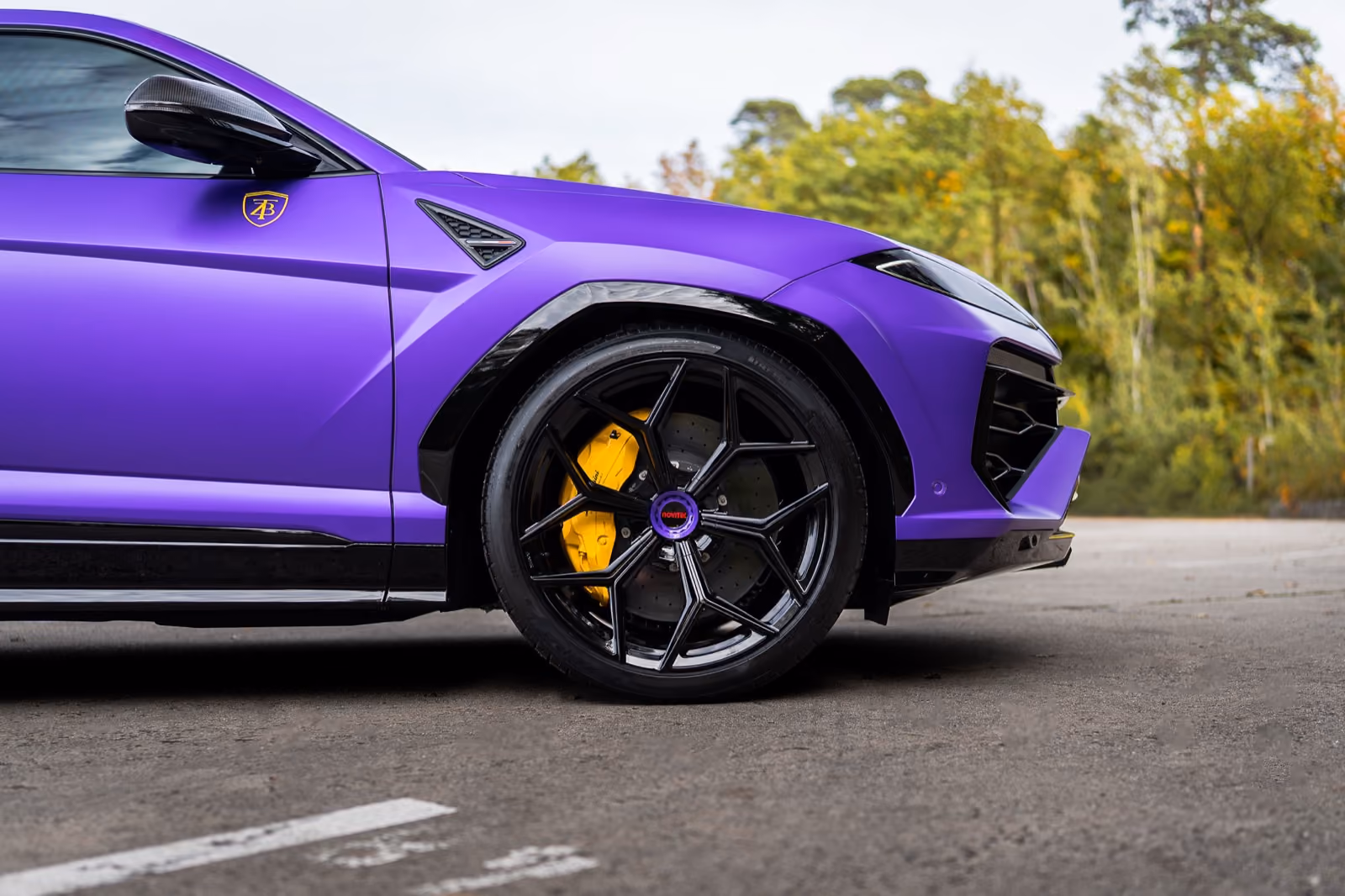 Seitliche Detailaufnahme eines mattviolett folierten Lamborghini Urus mit schwarzen Felgen