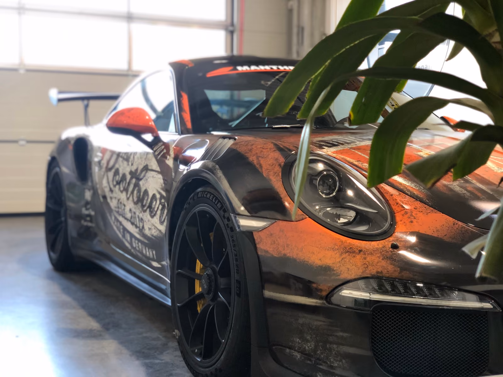 Porsche 911 GT3 RS mit Rost-Design-Folierung, Frontansicht in der Werkstatt