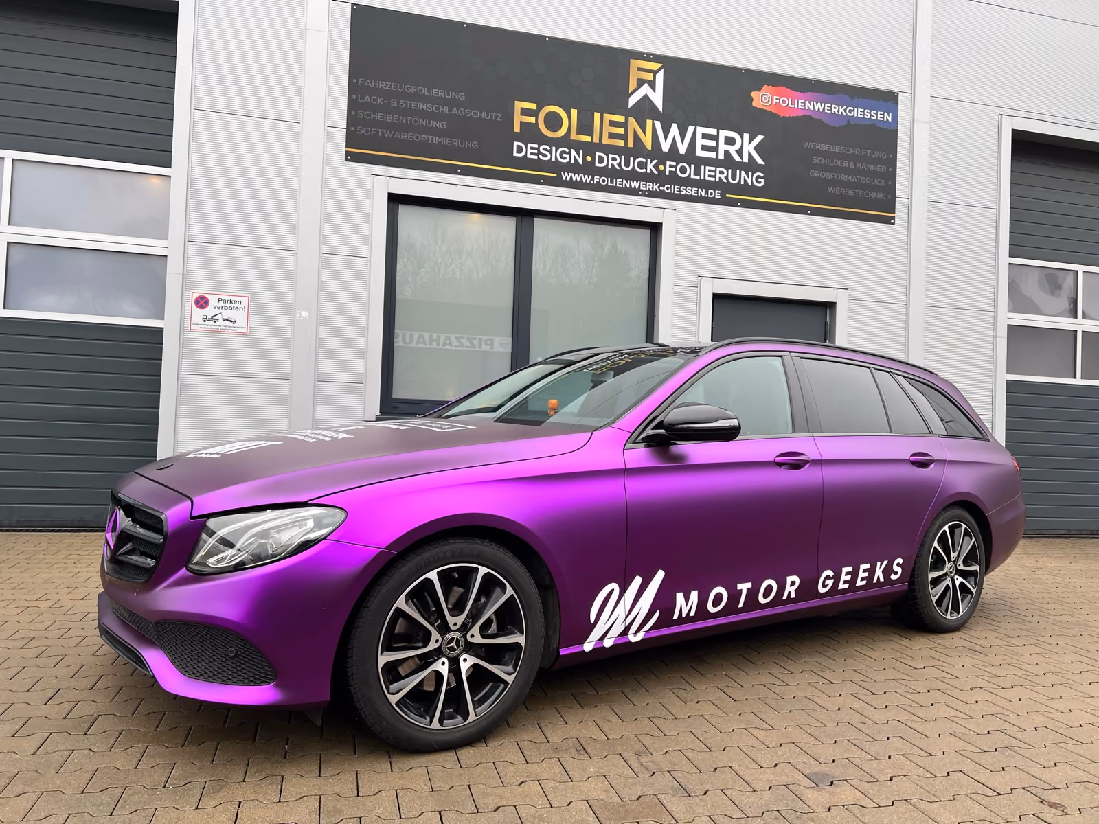 Mercedes E-Klasse T-Modell in Violett-Metallic foliert mit Werbebeschriftung vor dem Folienwerk Gießen