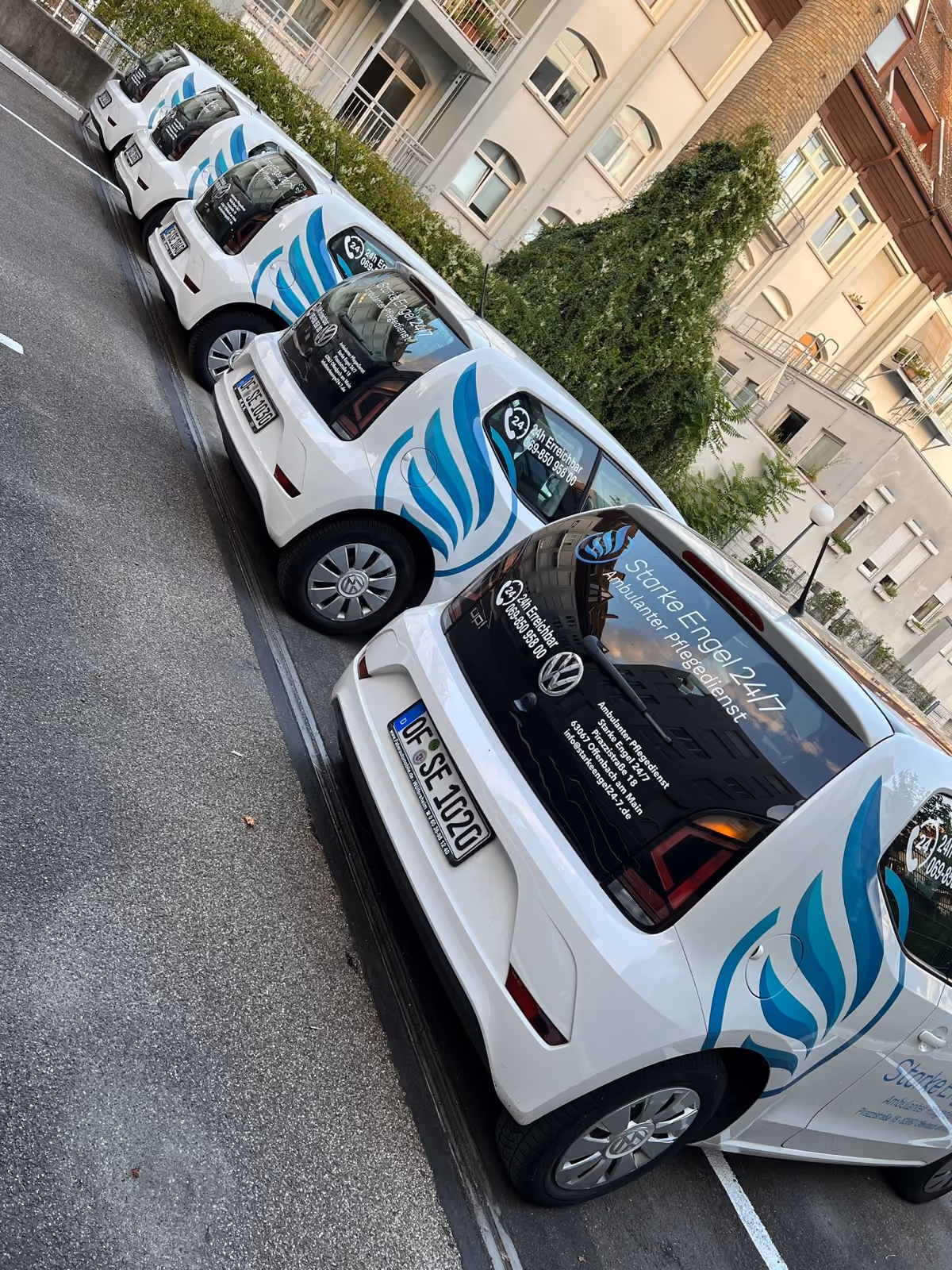 VW e-up Flotte mit Werbefolierung im Flügel-Design und beschrifteten Heckscheiben, Heckansicht