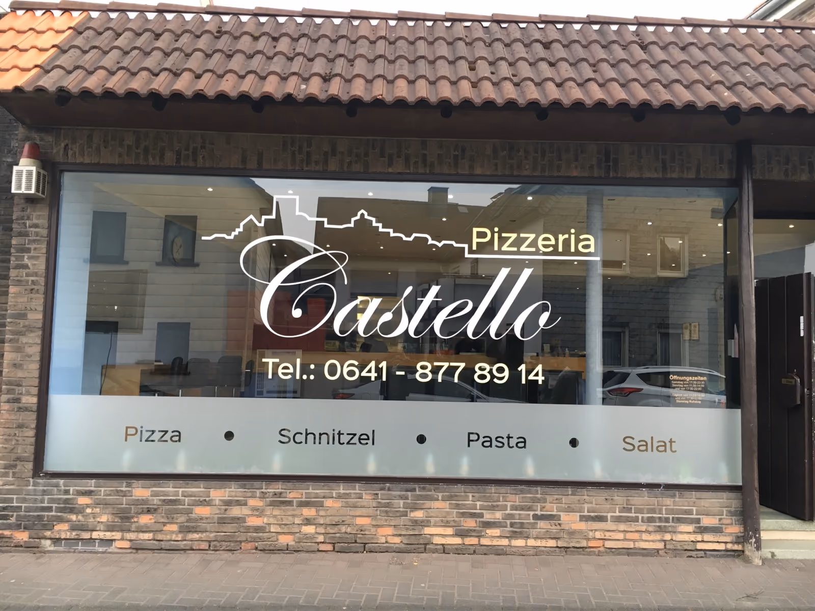 Schaufensterbeschriftung der Pizzeria Castello mit Logo, Telefonnummer und Speisenangebot