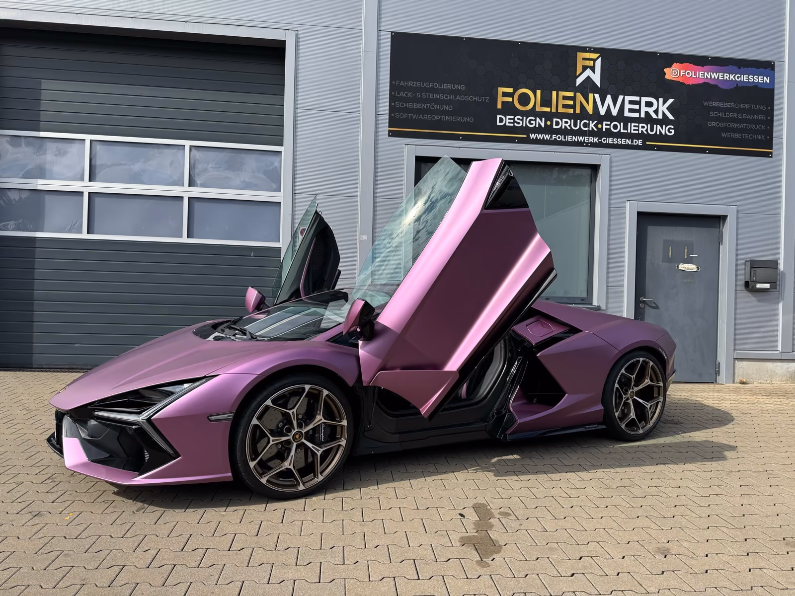 Lamborghini Revuelto in Satin-Violett foliert mit geöffneten Flügeltüren vor dem Folienwerk Gießen