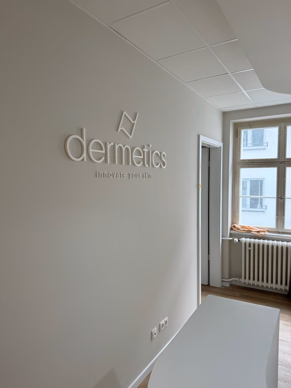 Weiße 3D-Logobuchstaben eines Kosmetikinstituts an der Wand, Werbetechnik-Referenz