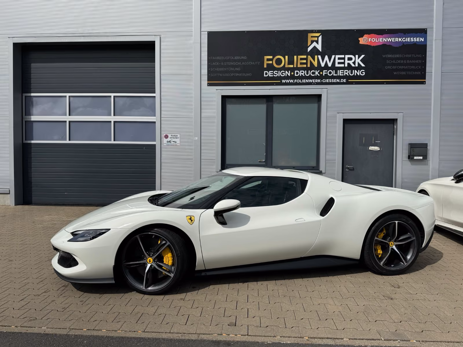 Weißer Ferrari 296 GTB mit Lackschutzfolierung vor dem Folienwerk Gießen