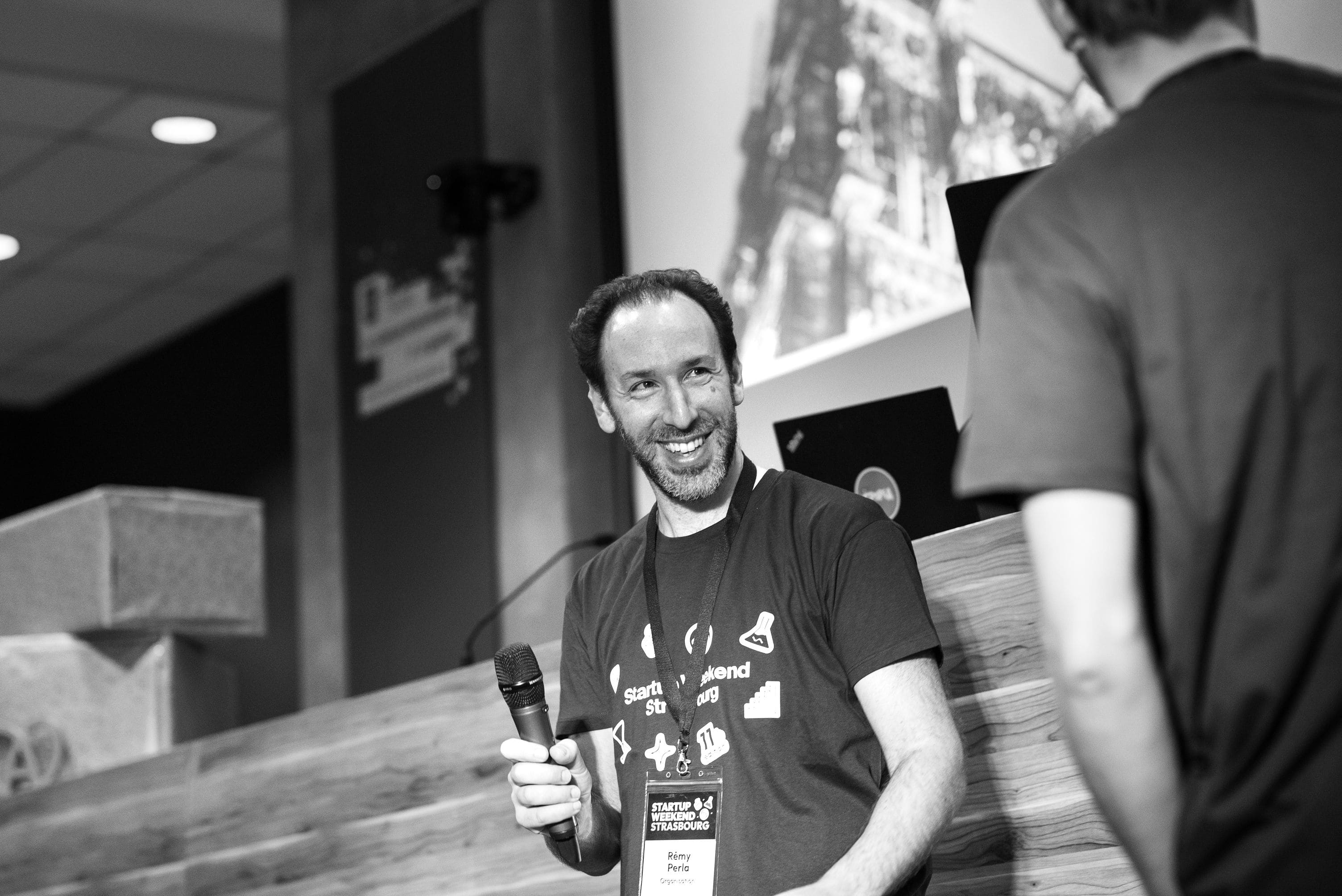 Un homme souriant tenant un microphone lors d'un événement Startup Weekend Strasbourg.