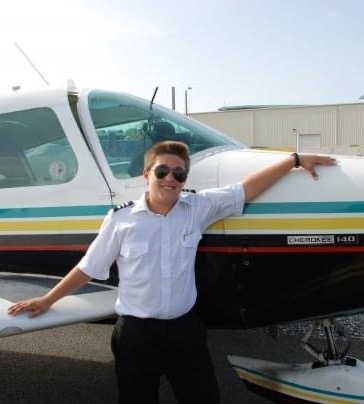 Andres Morales standing beside an aircraft during his early flight training.