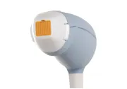Handheld laser hair removal device with a gray handle and white-orange treatment tip.