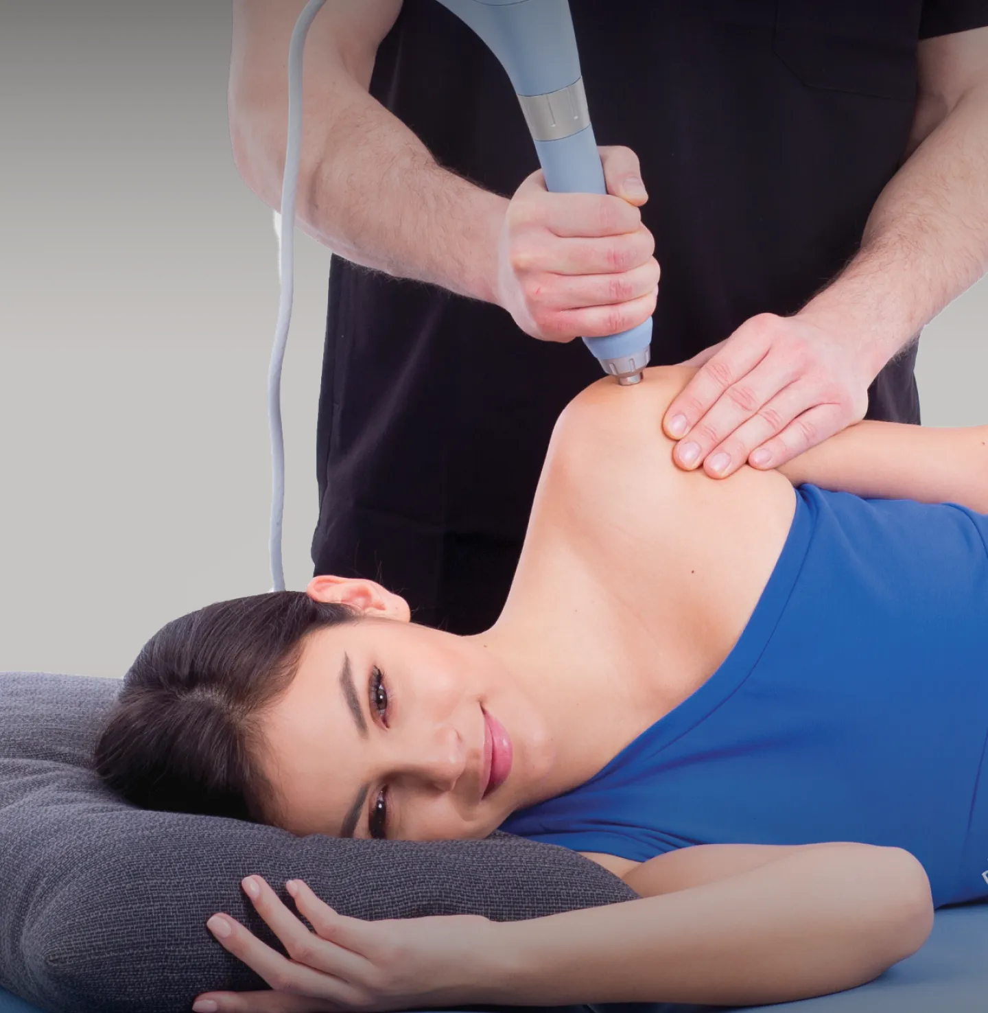 Behandlare utför rehabiliteringsbehandling på patients axel med BTL-terapeututrustning.