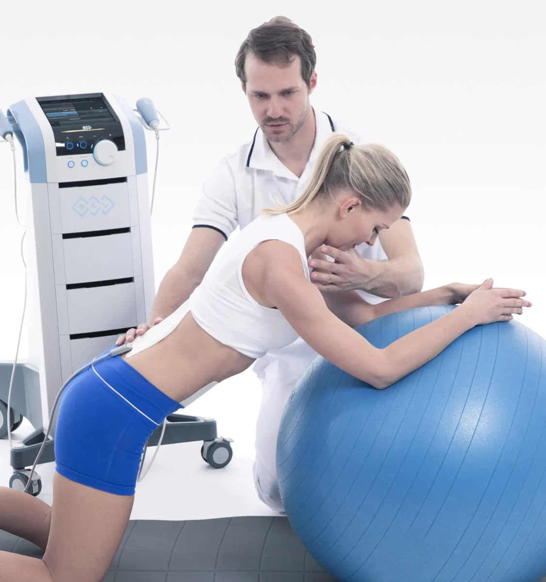 Sjukgymnast assisterar patient som utfor karnaktivering pa stabilitetsboll under BTL rehabilitering behandling, med BTL