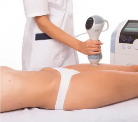 Läkare applicerar BTL EMTONE-enhet på patientens ben för behandling av celluliter och slapp hud.