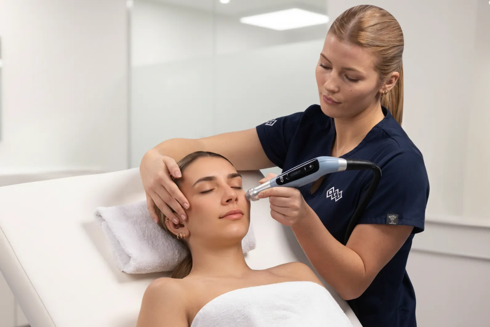 Terapeut applicerar BTL EMFUSION-behandling på patientens ansikte med handhållen enhet för att stärka (hudbarriär).