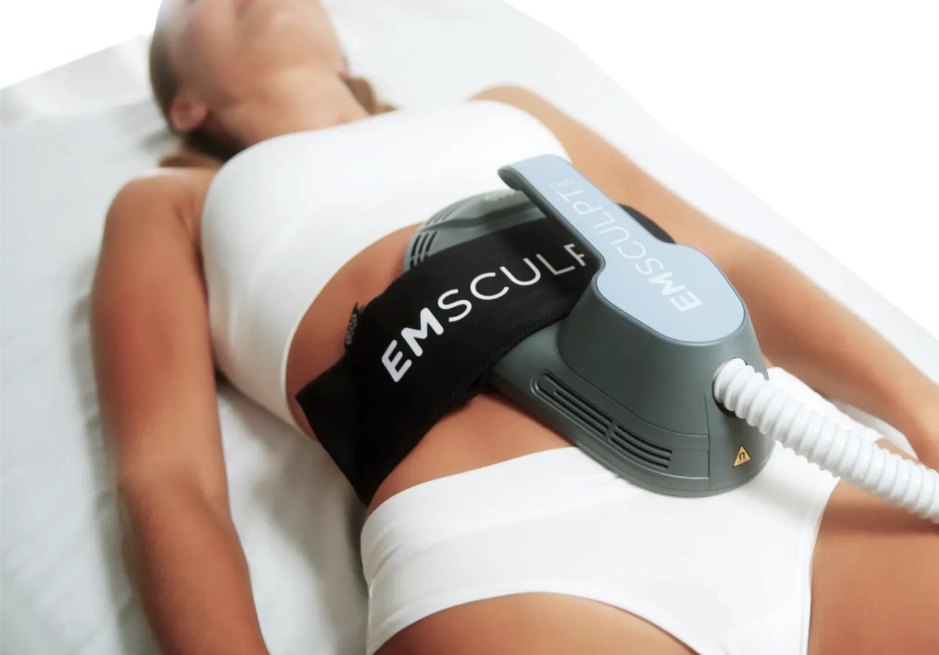 Patient ligger på behandlingsbädd medan en BTL EMSCULPT NEO-applikator appliceras mot buken för icke-invasiv kroppsformning.