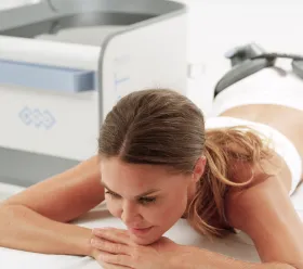 Patient undergår BTL EMSCULPT NEO-behandling för kroppsformning med applicerare mot buken.