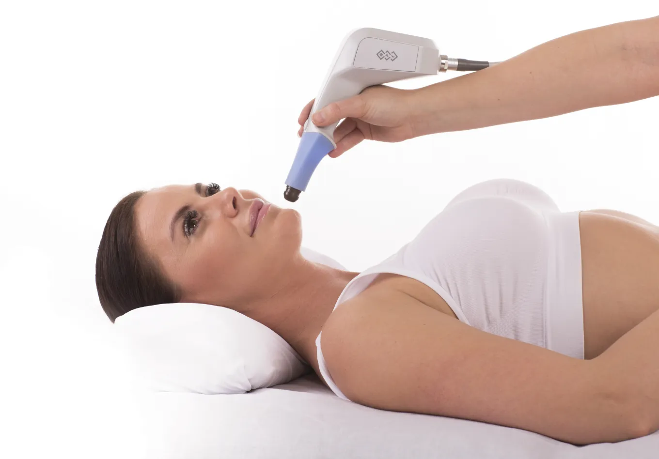 Patient ligger på behandlingsbrank medan behandlare applicerar BTL EXILIS ULTRA 360-applikator på ansiktet för