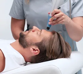 Patient mottar radiofrekvens- och ultraljudsbehandling i ansiktet med BTL EXILIS ULTRA 360-systemet.