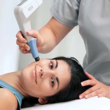 Kliniker använder BTL EXILIS ULTRA 360-applikator för radiofrekvens- och ultraljudsbehandling av ansiktet på en liggande