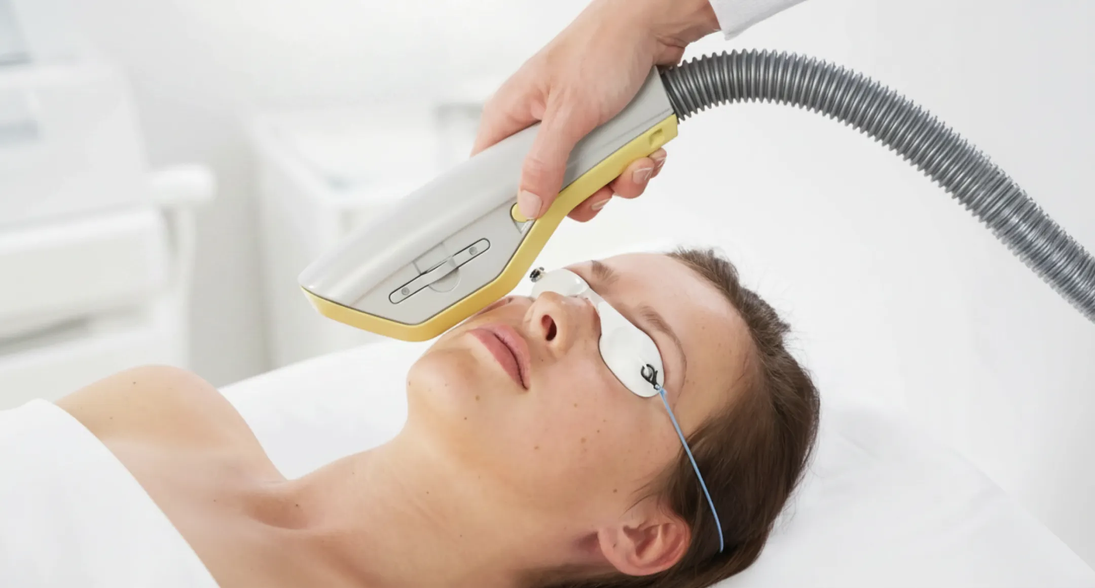 Patient mottar IPL-behandling på ansiktet med BTL EXILITE-enhet medan ögonskydd är på plats.